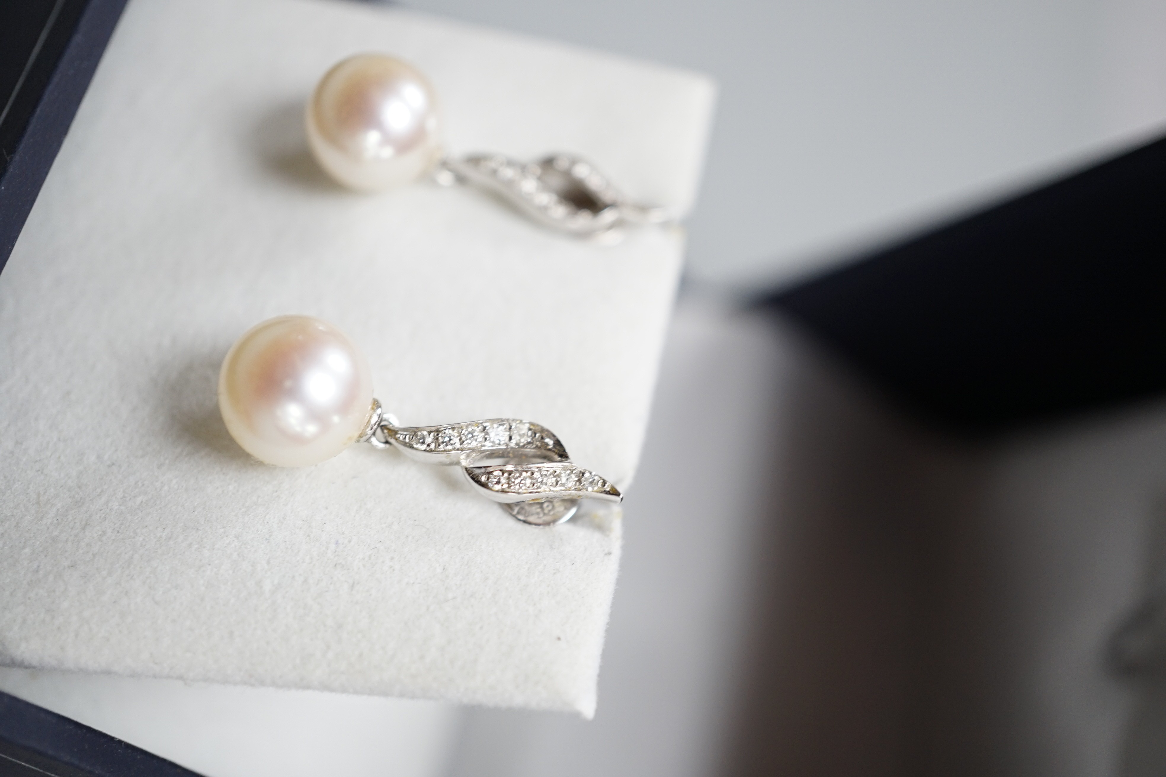 A modern pair of 14k white metal, cultured pearl and diamond set drop earrings, 24mm, gross weight 3.8 grams.